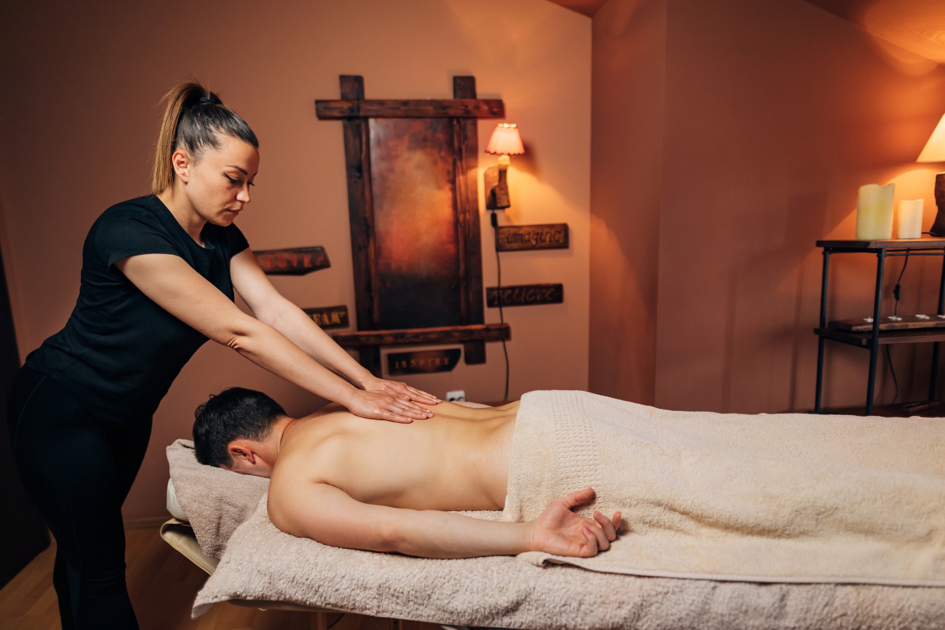 Masseuse, relaxing the client’s body, while performing the deep tissue massage, so all the muscle tension can go away
